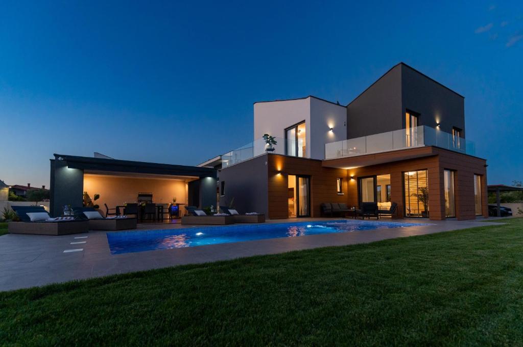 een groot huis met een achtertuin 's nachts bij Villa LiLa - Sunshine in Marčana