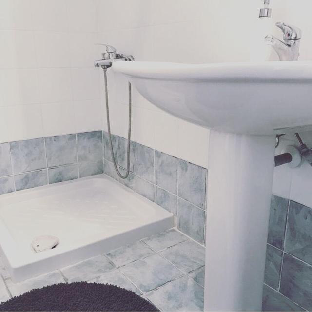 W łazience znajduje się biała umywalka i prysznic. w obiekcie Mola Kalyva SeaView Mesidrili w mieście Mola Kalyva