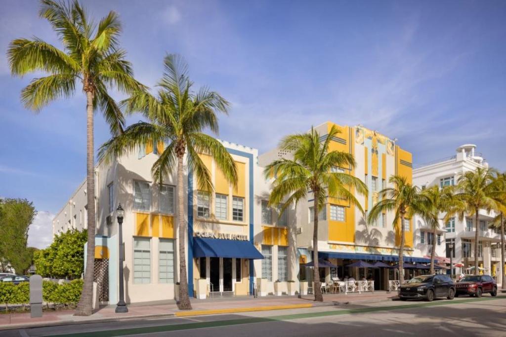 uma rua com palmeiras e um edifício amarelo em Ocean Five Hotel em Miami Beach