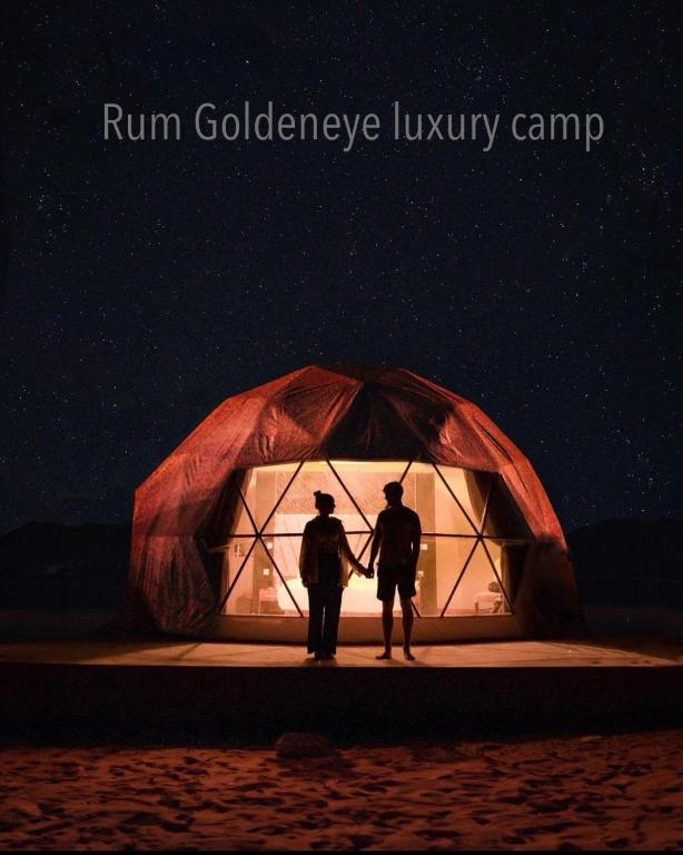 two people holding hands in front of a tent at Rum Goldeneye luxury camp in Wadi Rum