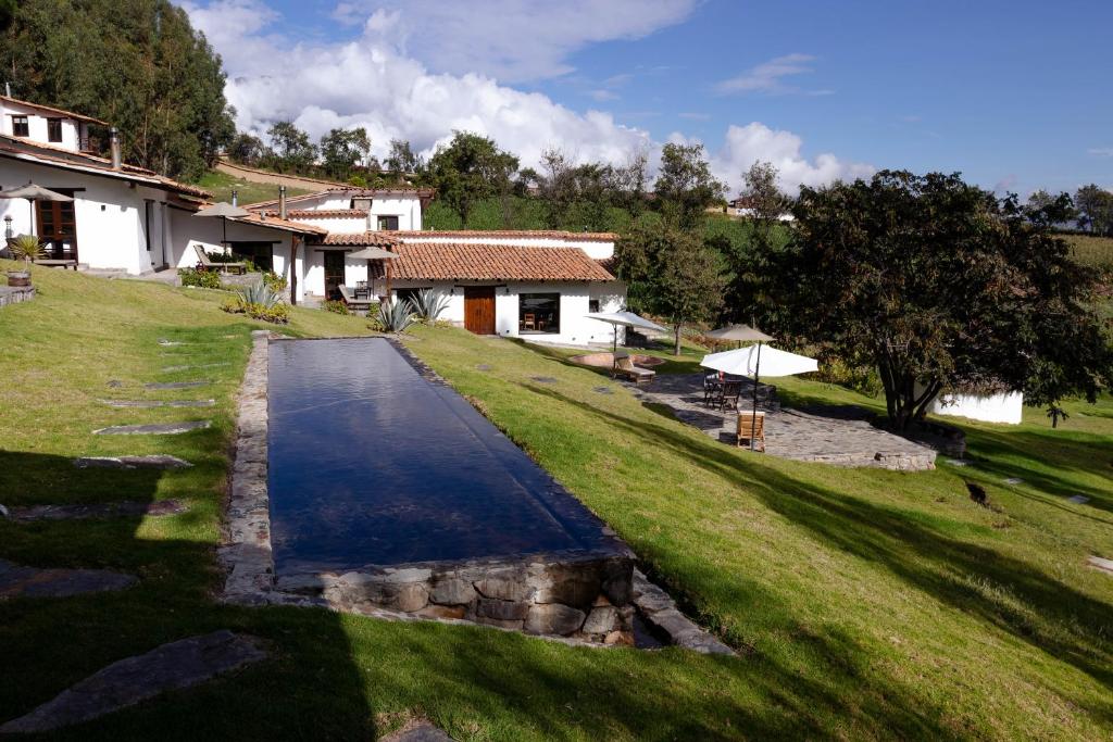 a driveway leading to a house in a field at Santa Cruz Eco Lodge in Huata