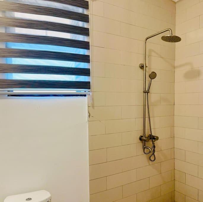 uma cabina de duche na casa de banho com uma janela em Spacious One Bedroom Apartment em Acra
