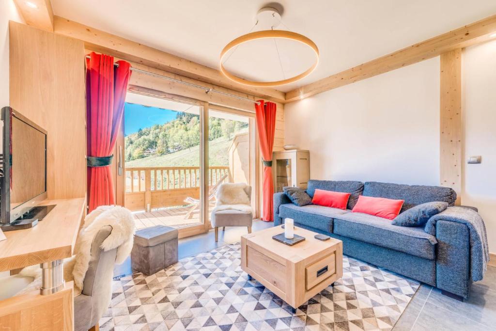 uma sala de estar com um sofá azul e uma mesa em Résidence Les Balcons EtoilÉs - 3 Pièces pour 6 Personnes 301 em Champagny-en-Vanoise