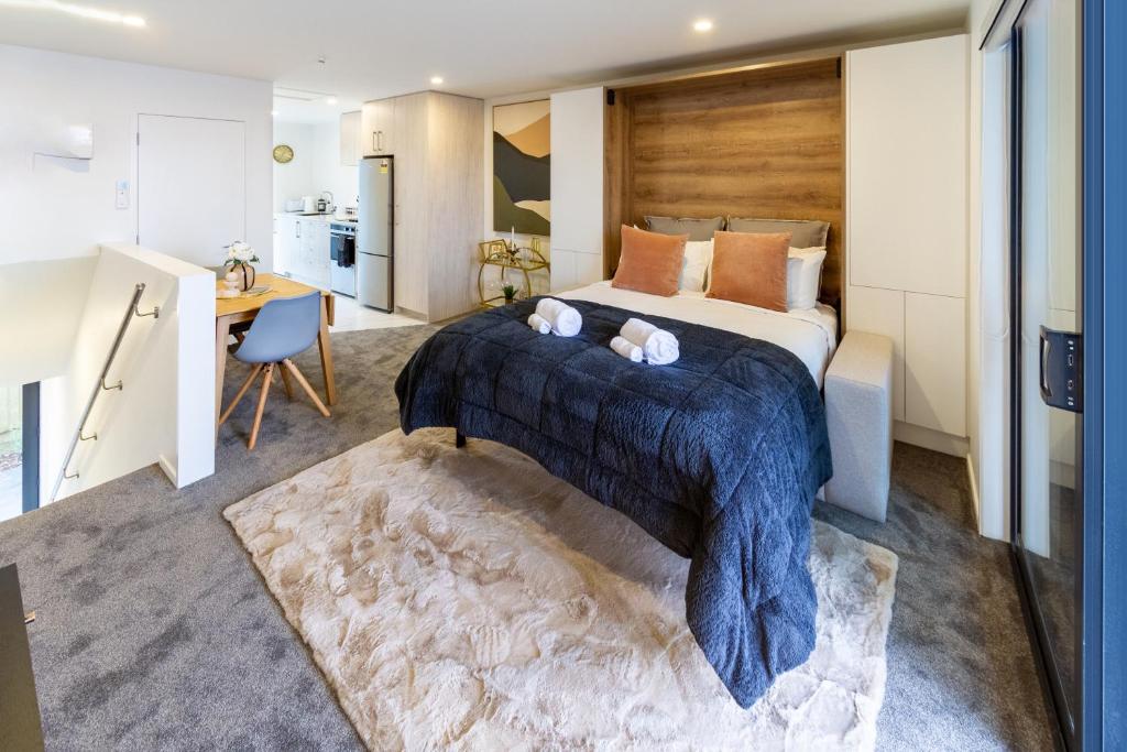 a bedroom with a large bed with a blue blanket at Urban Retreat at 8 Wilmer: Upper Level Studio Gem in Christchurch