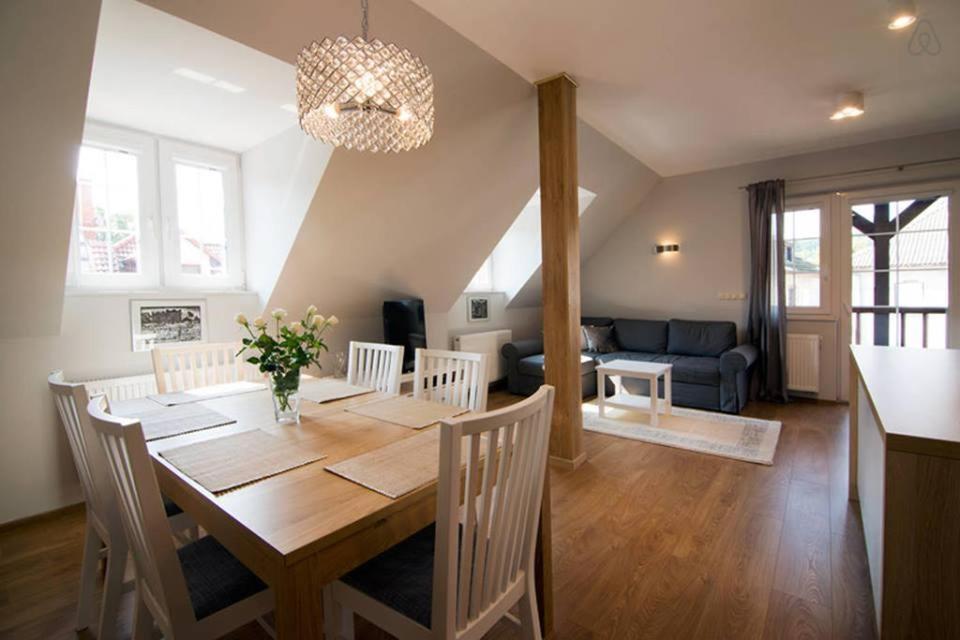 a dining room and living room with a table and chairs at APARTAMENTY TUŹNIKOWIE in Kazimierz Dolny