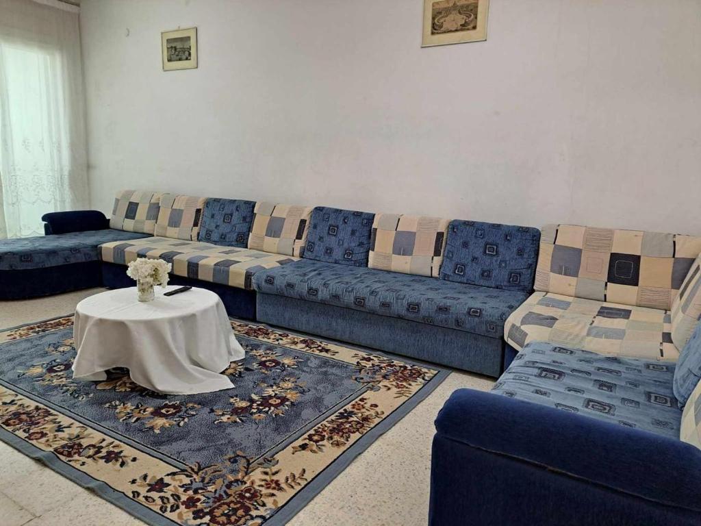un soggiorno con divano blu e tavolo di appartement a sahloul sousse a Sousse