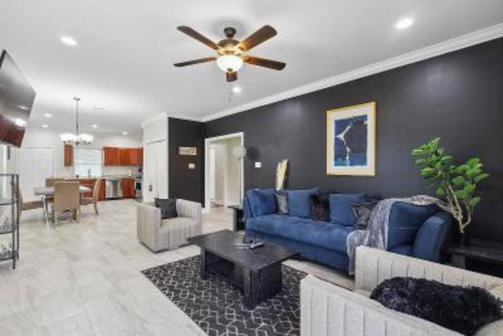 a living room with a blue couch and a ceiling fan at Jazz & Blues House in New Orleans