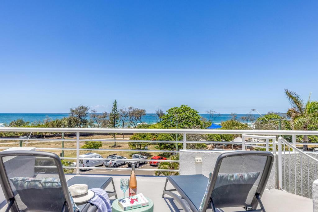 balcón con mesa, sillas y vistas al océano en Sundeck Gardens, en Maroochydore
