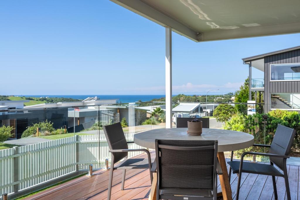 una mesa y sillas en un balcón con vistas al océano en Sea&Country Kiama - Stunning Views-Relaxing-Spacious-Deck-EVC en Kiama