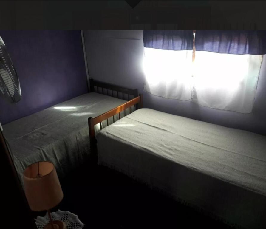 1 dormitorio con 2 camas individuales y ventana en Del muelle en Miramar