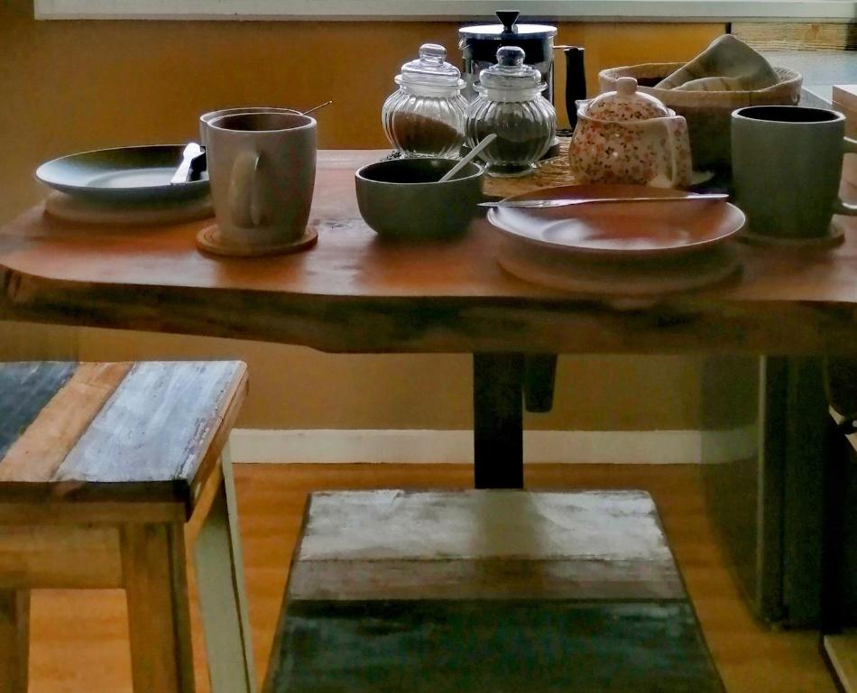 a wooden table with plates and cups on it at CasaMar ElQuisco in El Quisco