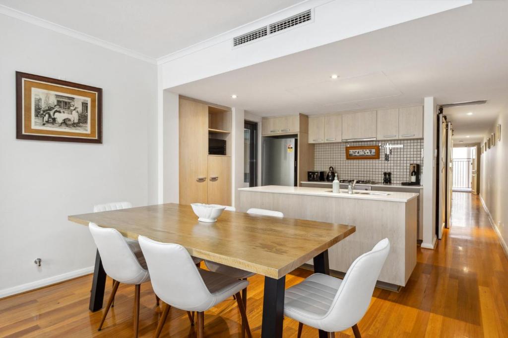 eine Küche und ein Esszimmer mit einem Holztisch und weißen Stühlen in der Unterkunft BANN2/5 - Bannister Heritage Hideaway in Fremantle