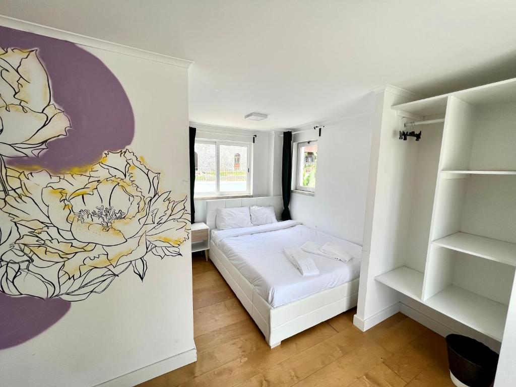 Un dormitorio con una cama con un mural de flores en la pared. en Oeiras Beach Guest House, en Oeiras