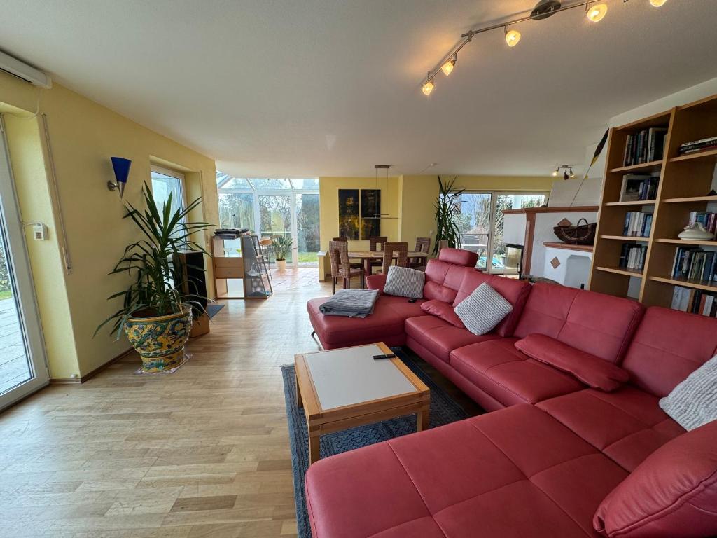 a living room with a red couch and a table at Ferienhaus Bergblick in Tettnang
