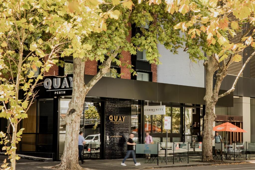 una mujer caminando delante de una tienda en Quay Perth en Perth