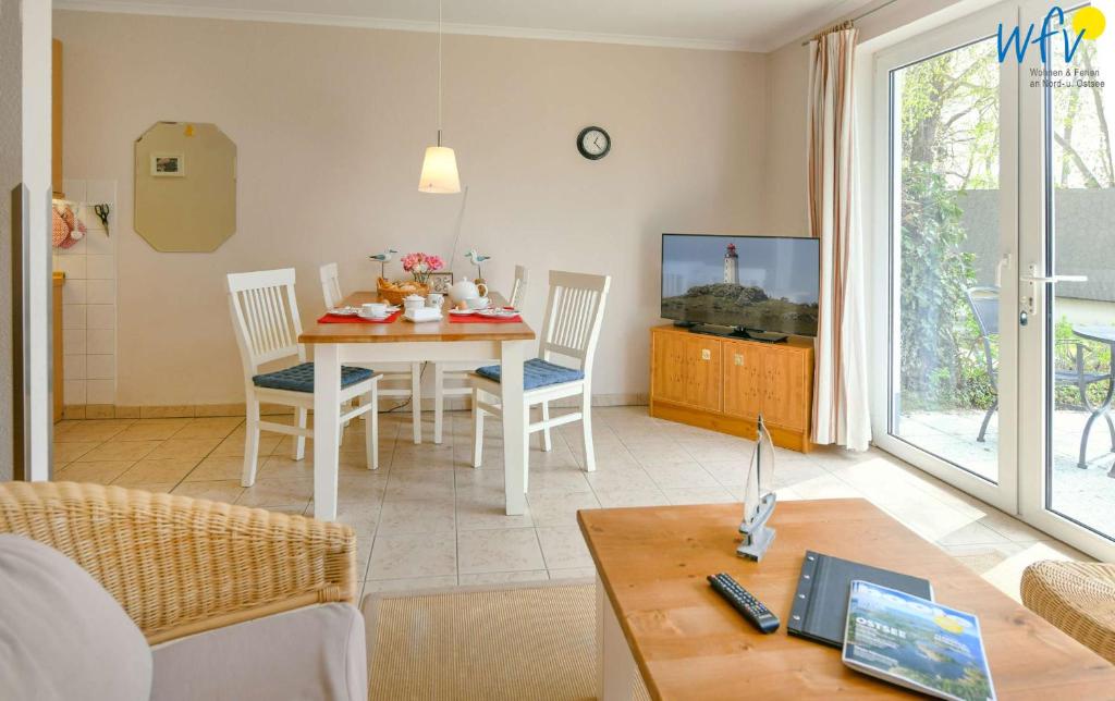a living room with a table and chairs and a television at Haus am Hövt - Ferienwohnung 10 in Göhren