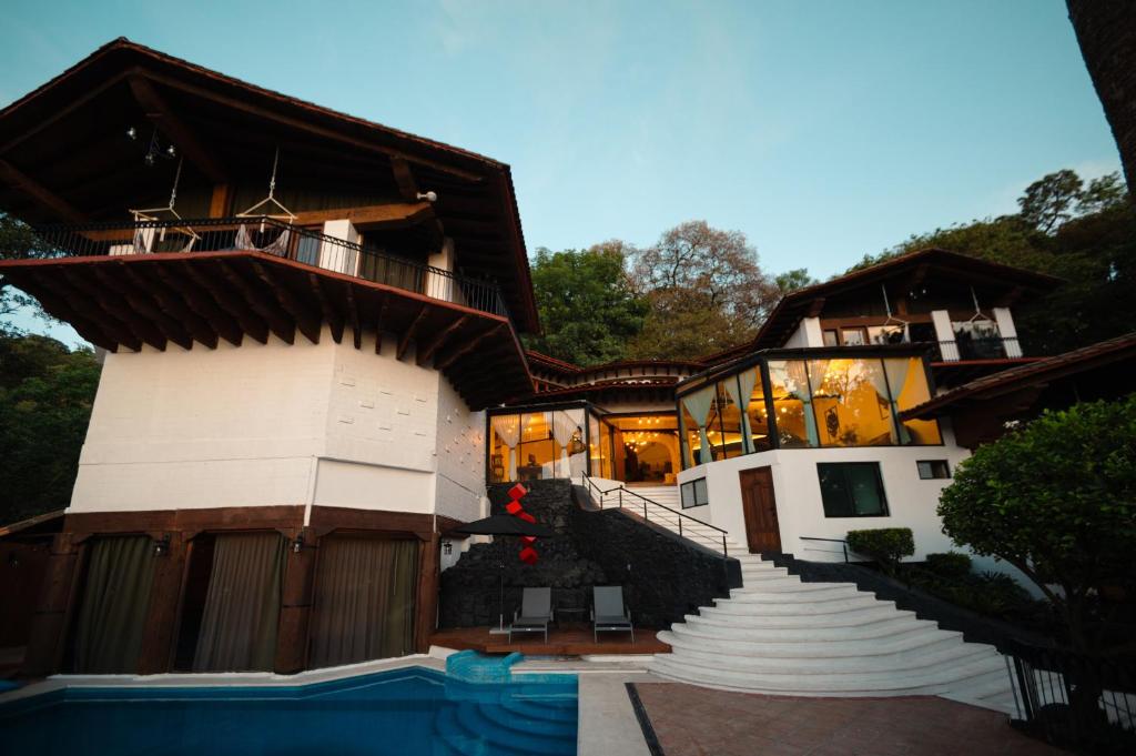 una casa con escaleras y una piscina frente a ella en BOTANIQ HOTEL BOUTIQUE, en Valle de Bravo