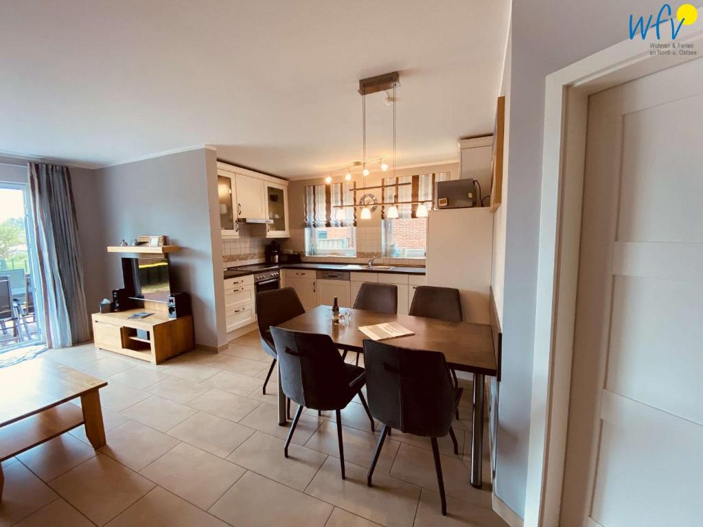 Una cocina y un comedor con mesa y sillas. en Ferienwohnung Weidenkieker, en Borkum