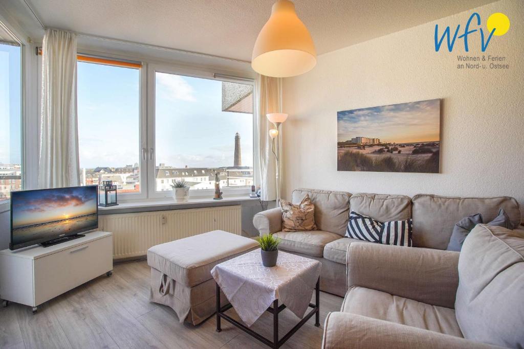 a living room with a couch and a tv at Ferienhaus Seeblick - Wohnung 96 in Borkum