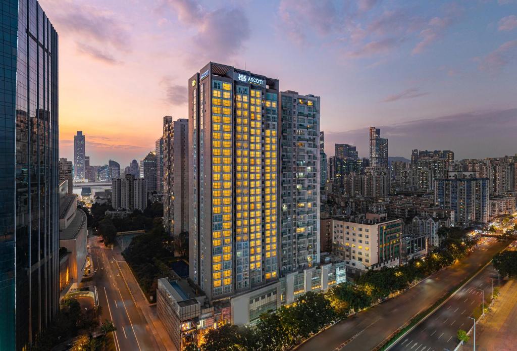 a tall building with yellow windows in a city at Ascott Guangzhou, Free Shuttle Bus For Canton Fair in Guangzhou