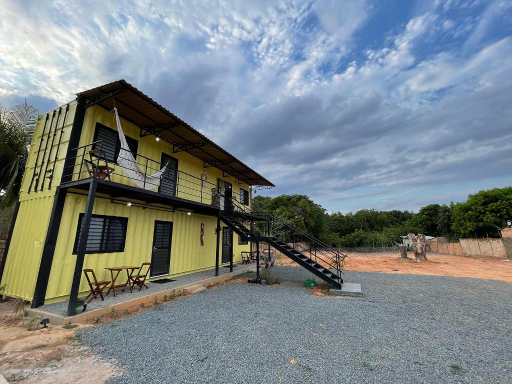Suíte Contêiner Roraima في بوا فيستا: منزل اصفر امامه درج