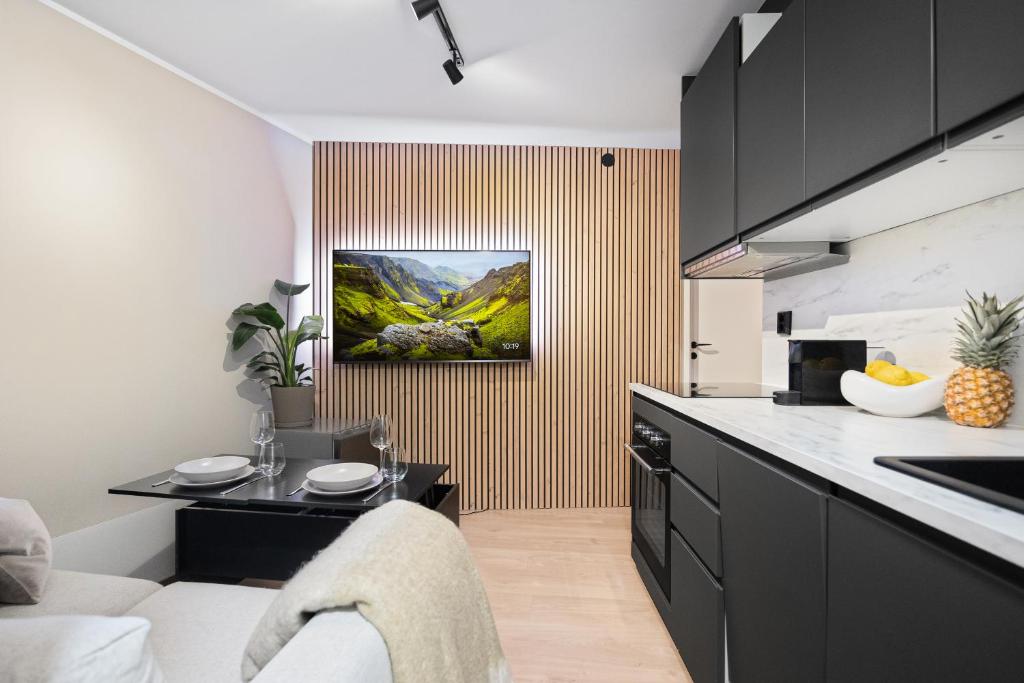 eine Küche mit schwarzen Schränken und einer Arbeitsplatte in der Unterkunft King bed - Behind Bryggen - Renovated des 23 in Bergen