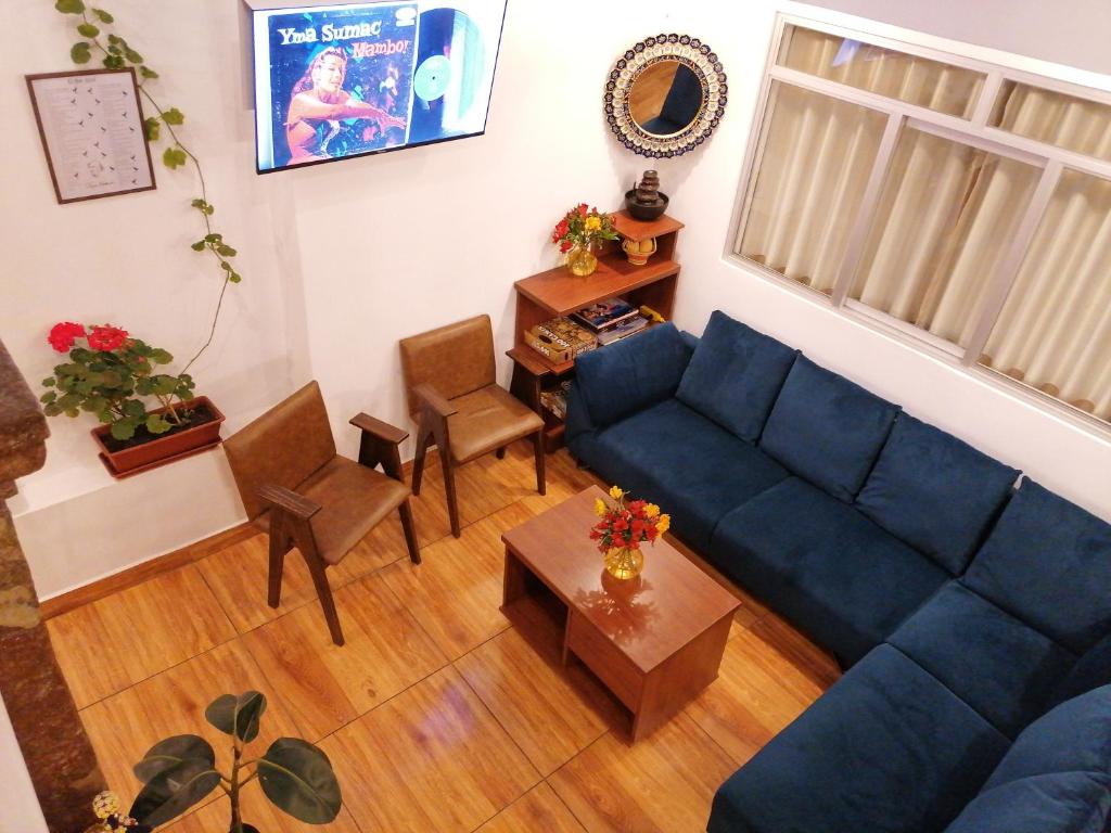 a living room with a blue couch and a table at El Ave Azul Boutique Hotel Cusco in Cusco