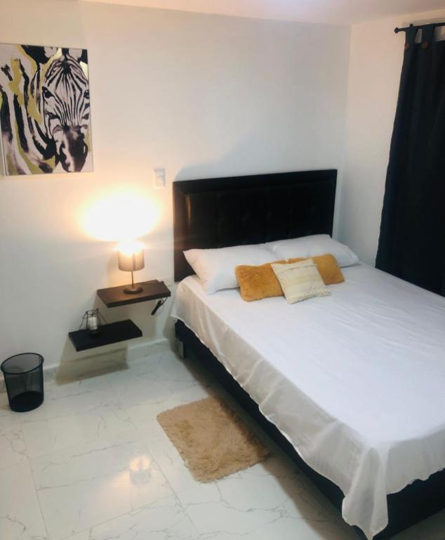 a bedroom with a large bed with a lamp on it at Hostel Campoamor in Medellín