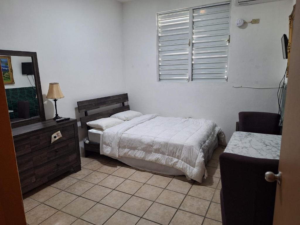 a bedroom with two beds and a dresser and a window at Humacao guest house in Humacao