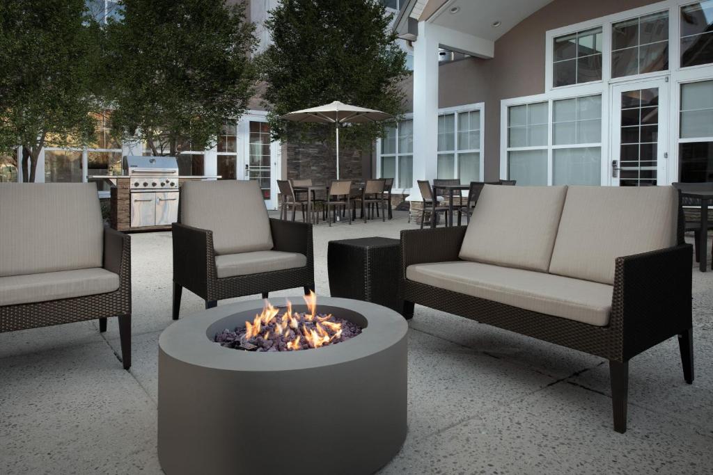 - un ensemble de chaises et un foyer extérieur sur la terrasse dans l'établissement Residence Inn by Marriott Fayetteville Cross Creek, à Fayetteville