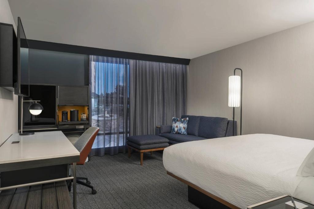 レイク・シティにあるCourtyard by Marriott Lake Cityのベッドとデスクが備わるホテルルームです。