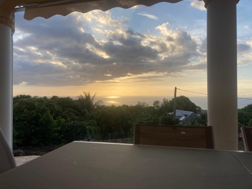 d'un balcon offrant une vue sur le coucher du soleil. dans l'établissement Villa bohème Gîte vue sur mer et montagne, à Vieux-Habitants