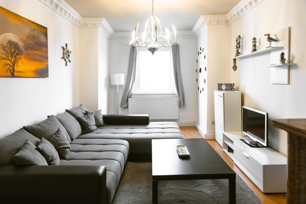 a living room with a couch and a tv at Kaminstube im Goethequartier in Bremerhaven