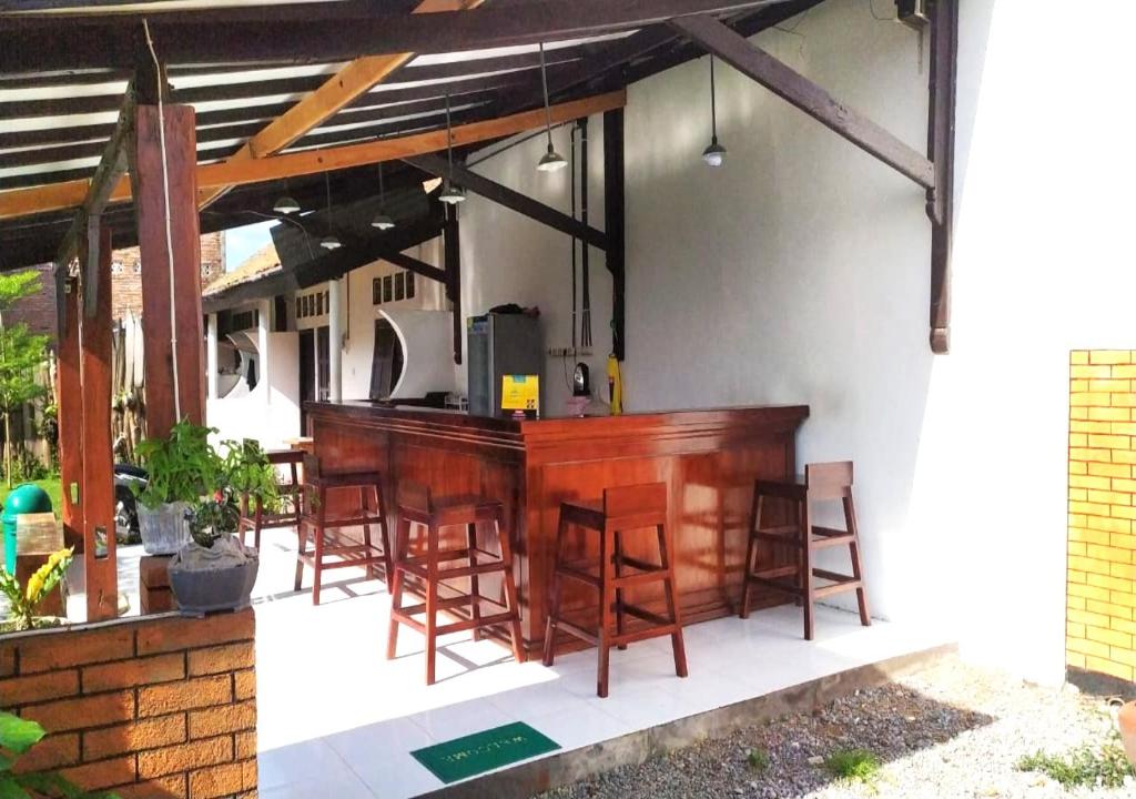 a bar on the side of a house with chairs at Aipayung Homestay 