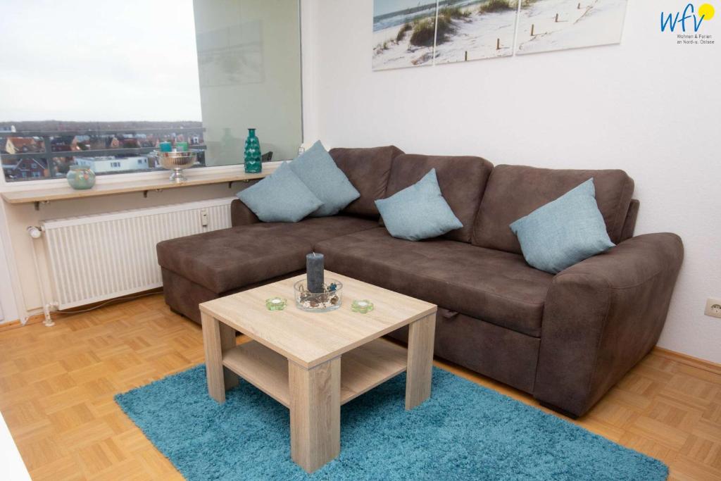 a living room with a brown couch and a coffee table at Ferienhaus Seeblick - Wohnung 85 in Borkum