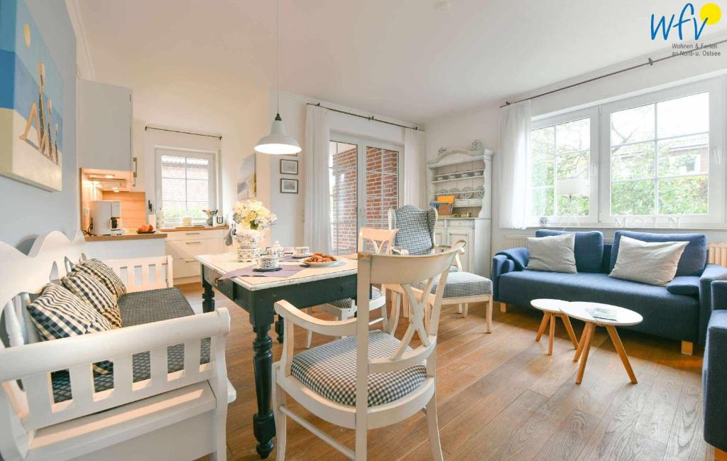 a living room with a table and a blue couch at Luv und Lee - Ferienwohnung Juister Stuv in Juist