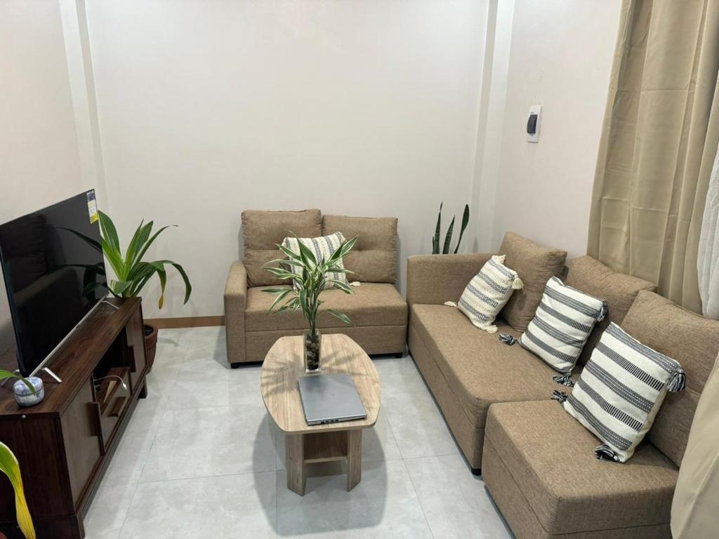 ein Wohnzimmer mit einem Sofa und einem TV in der Unterkunft Comfy Staycation II in Sorsogon City 2 bedroom for group or family in Sorsogon