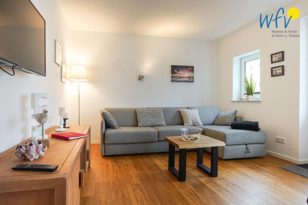 a living room with a couch and a table at Appartement-Haus Regina Ferienwohnung Sonnendeck in Borkum