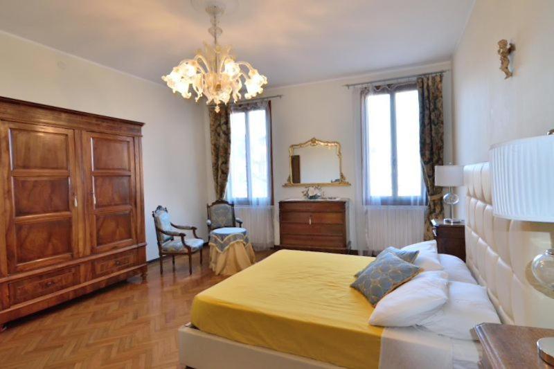 a bedroom with a yellow bed and a chandelier at Corte Stupenda in Venice
