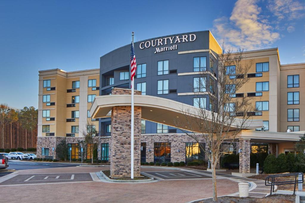 Um edifício com uma bandeira americana à frente. em Courtyard by Marriott Atlanta Lithia Springs em Lithia Springs