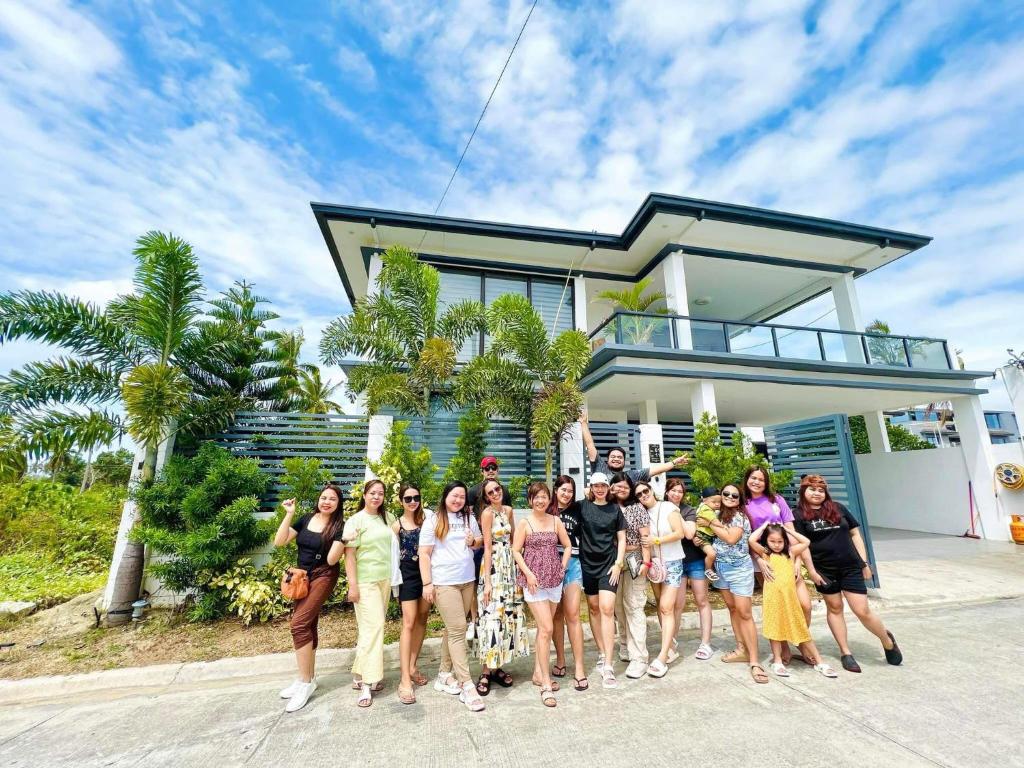 a group of people standing in front of a house at Villa Tobias San Juan Batangas in Batangas City