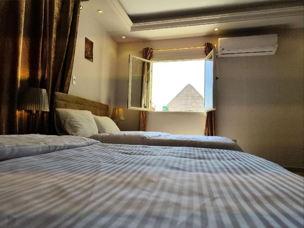 Een bed of bedden in een kamer bij Hur Pyramids land inn