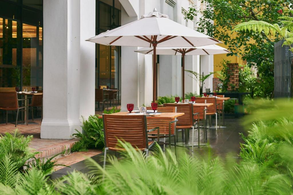 An outdoor dining terrace set among lush greenery beside the hotel.