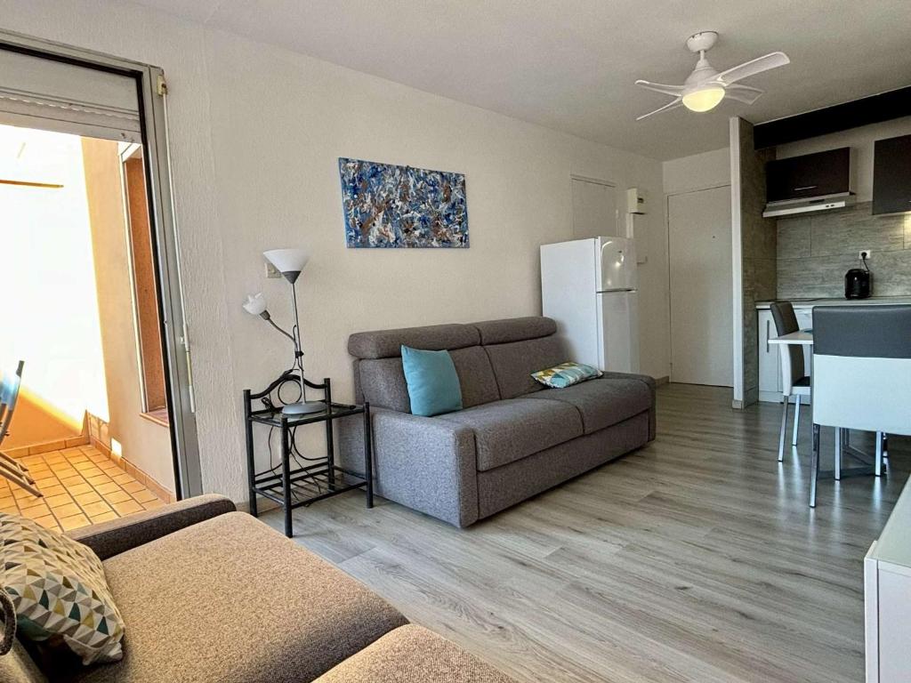un salon avec un canapé et une cuisine dans l'établissement Appartement cosy 4 pers. à 400m de la plage, piscine, terrasse, parking sécurisé - FR-1-225-807, à Argelès-sur-Mer