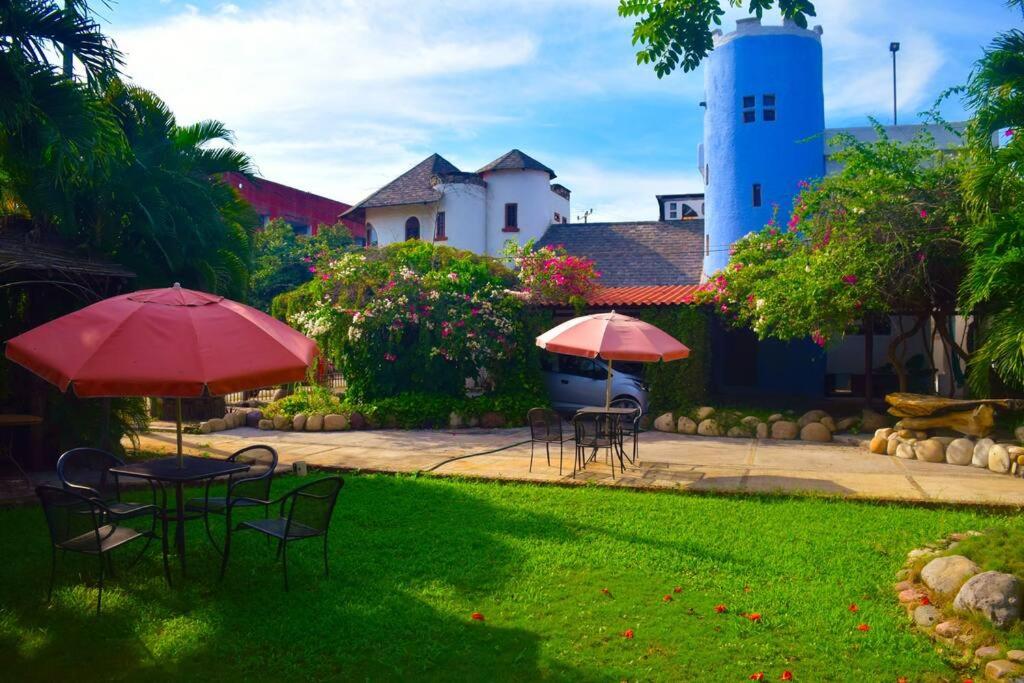 een tuin met tafels en stoelen met parasols bij El Castillo Mágico (Estancia Inolvidable) LZC in Lázaro Cárdenas