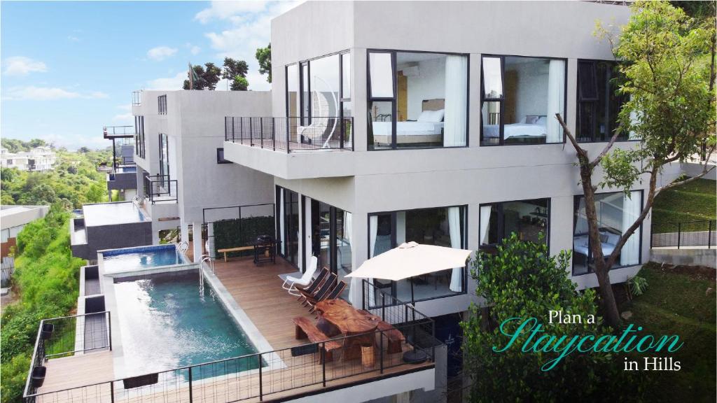 a large white building with a swimming pool at Thalassaville Dago Bandung in Bengkok