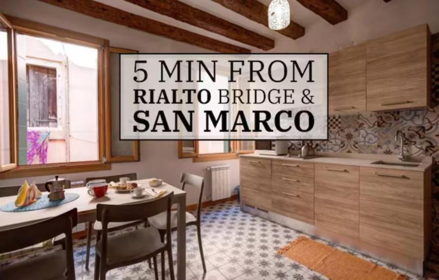 a kitchen with a table and a sign that reads min from radio bridge at Rialto Bridge! Comodo appartamento in centro - 2 in Venice