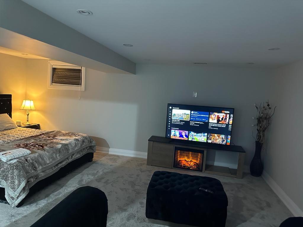 布蘭普頓的住宿－Langston Beautiful Home，一间卧室配有一张床和一台平面电视