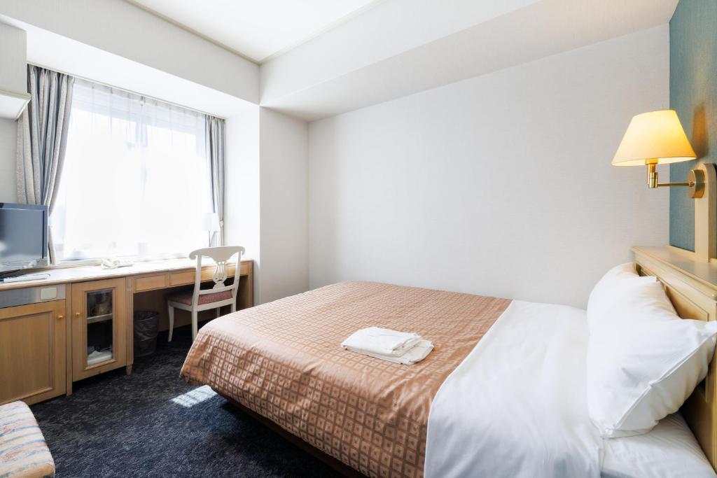 Postel nebo postele na pokoji v ubytování Hiroshima Intelligent Hotel Annex