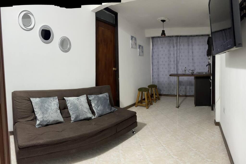ein Wohnzimmer mit einem Sofa und einem Tisch in der Unterkunft Apartamento en Bello Medellín in Bello